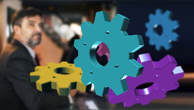 A photo of a businessman in the background with multi-colored gears in the front, symbolizing a complete guide to marketing automatio
