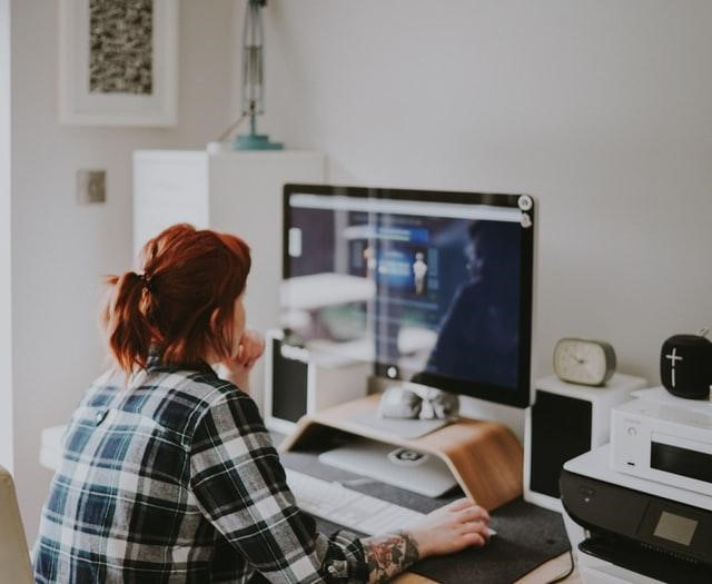 A woman reading about how to determine which social media platform is right for your business on her computer.